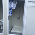Contenedor sanitario con inodoro y ducha.